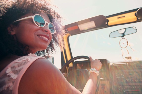 Woman with sunglasses driving a convertible car