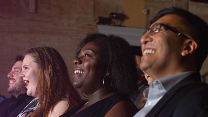 four people sitting watching a show
