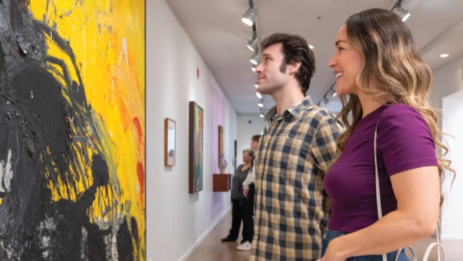 people looking at paintings in a museum