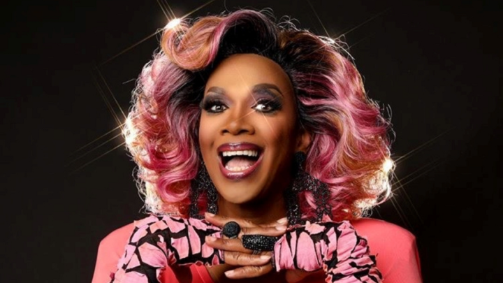 Headshot of Harmonica Sunbeam, a drag queen, wearing all pink
