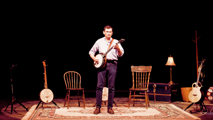 Man on stage playing a banjo