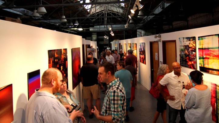 a stretch of art exhibits occupied with guests mingling about them