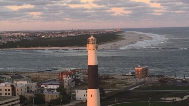lighthouse by the water during sunset