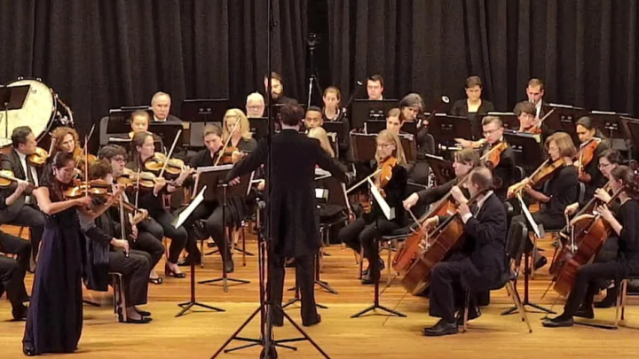 a conductor in front of a small orchestra
