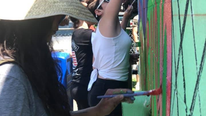 A group of women painting a mural