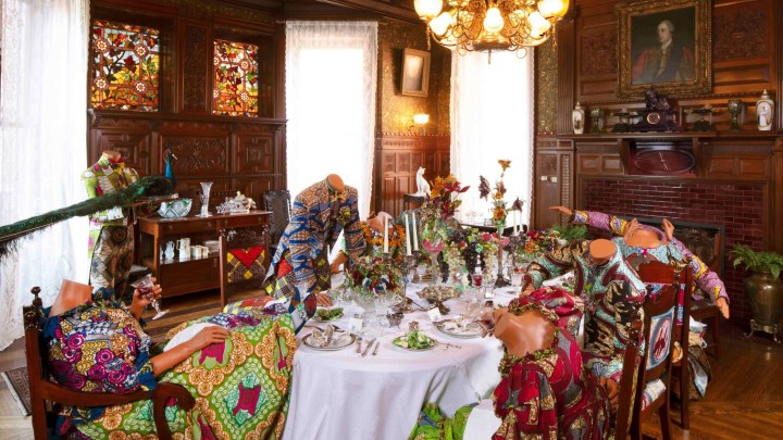 Elaborate table setting with mannequins sitting around dressed in period garb made of African inspired print.