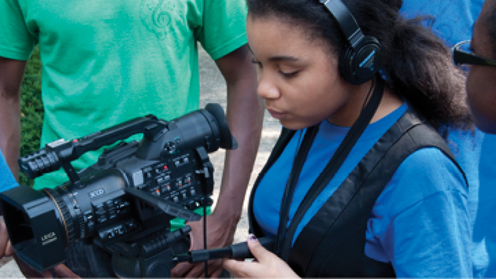 Student learning to operate a video camera.