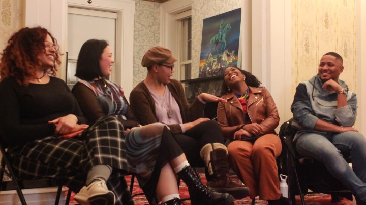 Deonté Griffin Quick and others sit laughing at a reading.