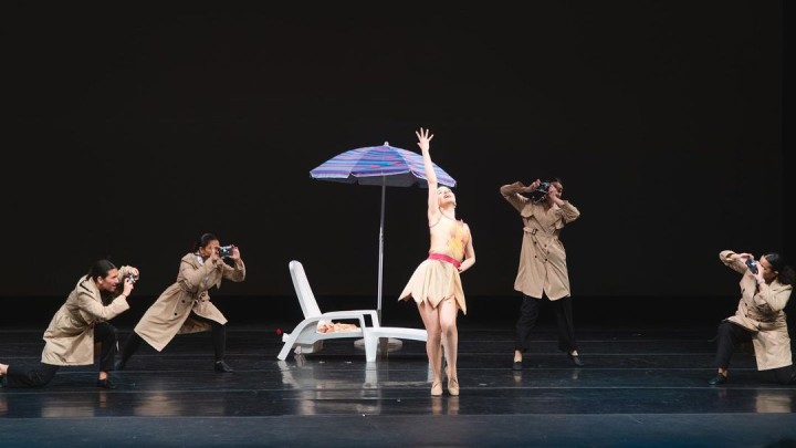 Performers on stage in a tableau of dance.
